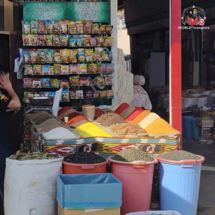 Colourful spice stall, with piles of spices and dried goods for sale at a market